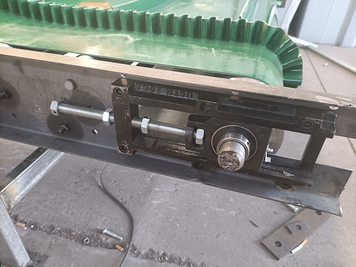 Close-up detail of the heavy-gauge steel structural frame and precision bearing assembly of an industrial conveyor system, highlighting engineering excellence and quality construction.