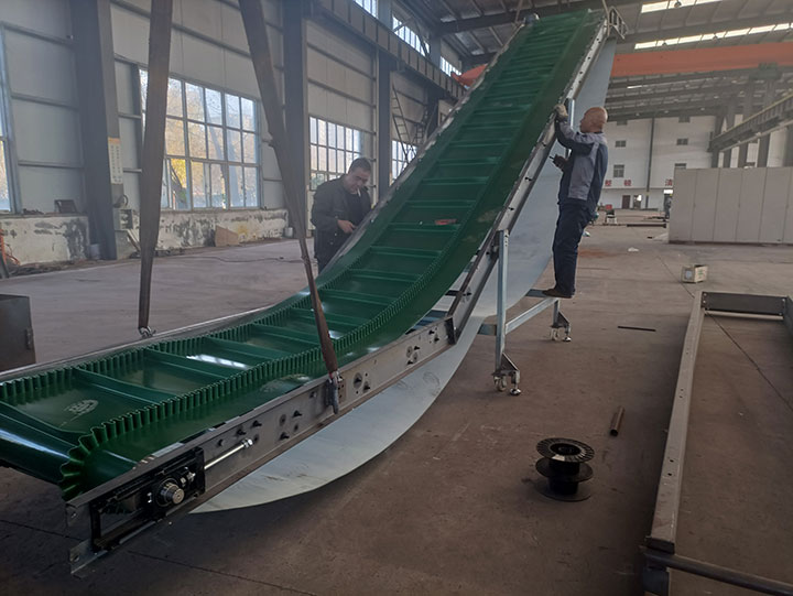 Custom industrial heat resistant conveyor belt featuring large green cleats in a gooseneck configuration, assembled in DAHAN workshop to meet unique geometric demands.