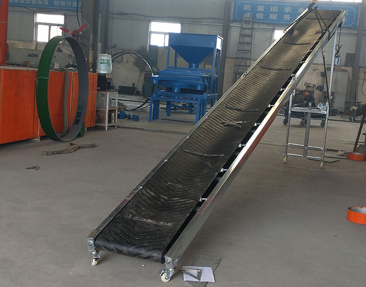 Inclined belt conveyor with corrugated sidewall and cleats for material handling selection.